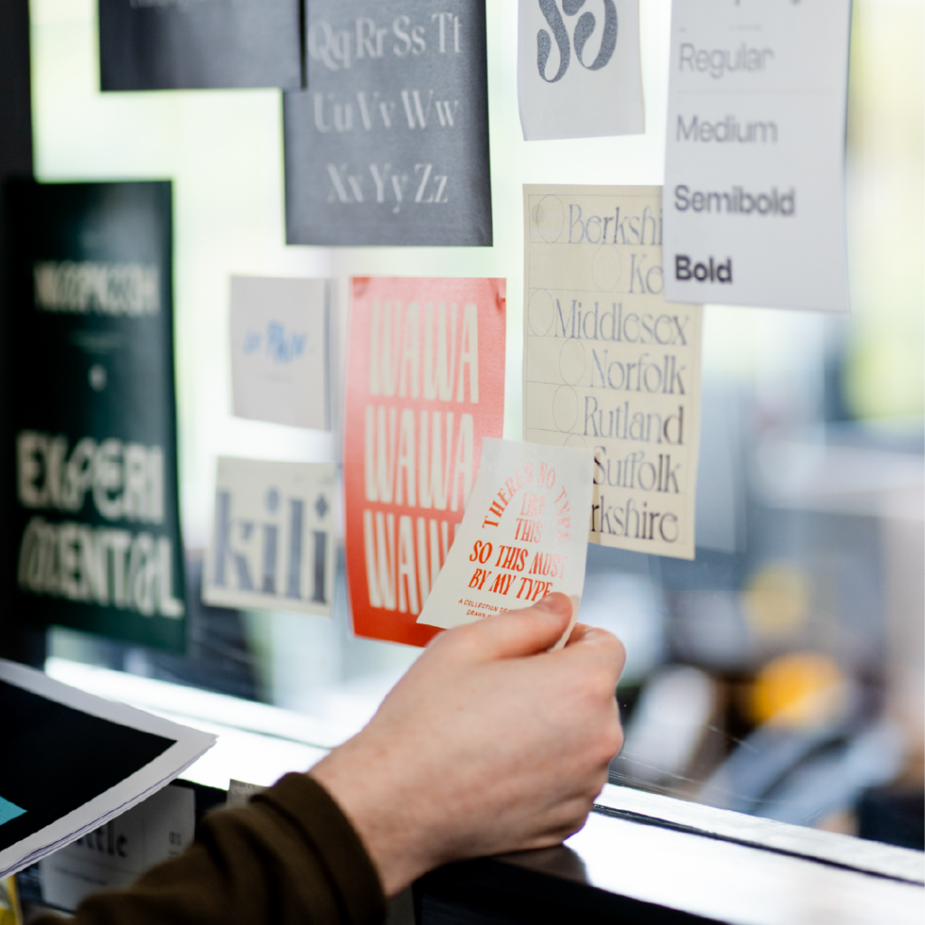 Hand placing design research onto wall during design meeting