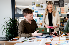 Designers discussing design work around board room table