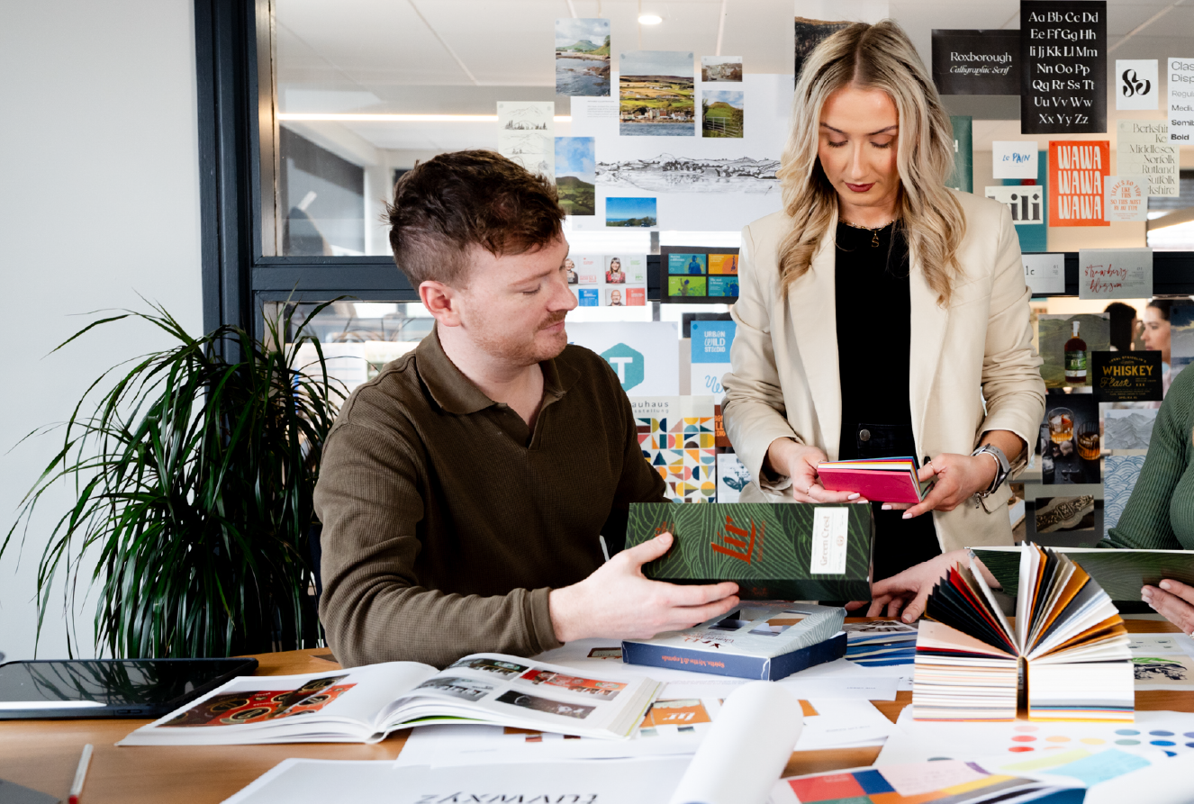 Designers discussing design work around board room table